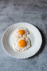 Egg poach sunny side up a healthy food ingredient on a plate. View from top, selective focus.