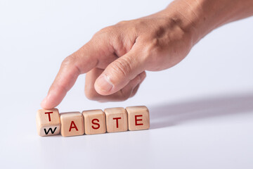 hand holding dice with text for illustration of "Taste and Waste" words
