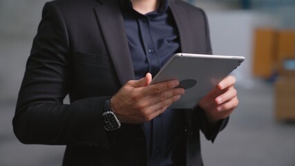 Factory manager using tablet computer in warehouse or factory . Industry and supply chain...