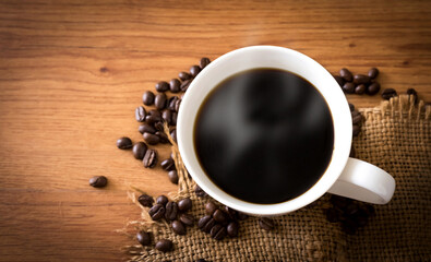 cup of coffee and coffee beans on old wooden background.
