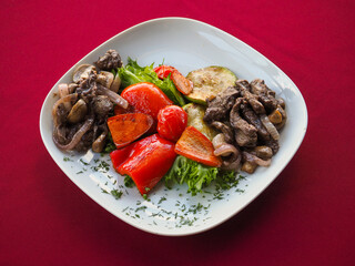 Beefsteak with tomato and herbs on a red background