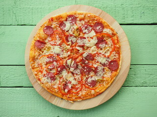 pizza on a wooden green background. Italian kitchen