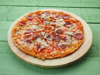 pizza on a wooden green background. Italian kitchen