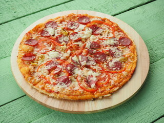 pizza on a wooden green background. Italian kitchen