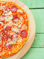 pizza on a wooden green background. Italian kitchen