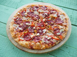 pizza on a wooden green background. Italian kitchen