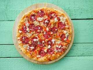 pizza on a wooden green background. Italian kitchen