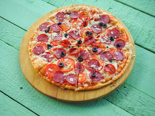pizza on a wooden green background. Italian kitchen