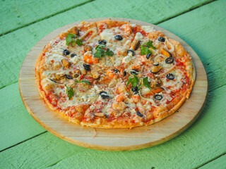 pizza on a wooden green background. Italian kitchen