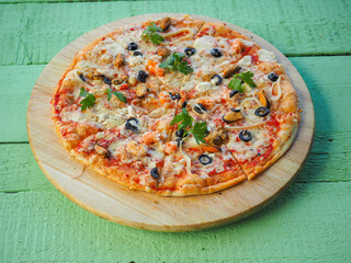 pizza on a wooden green background. Italian kitchen