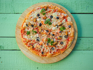 pizza on a wooden green background. Italian kitchen