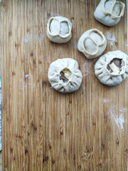 Rows of tasty buryat or mongolian, chinese buuza or baozi. Asian steamed food made of dough ban and meat.