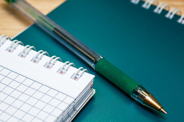 two notebooks and a fountain pen are on the table