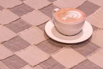 Empty space for text or logo. A cup of cappuccino on the table 