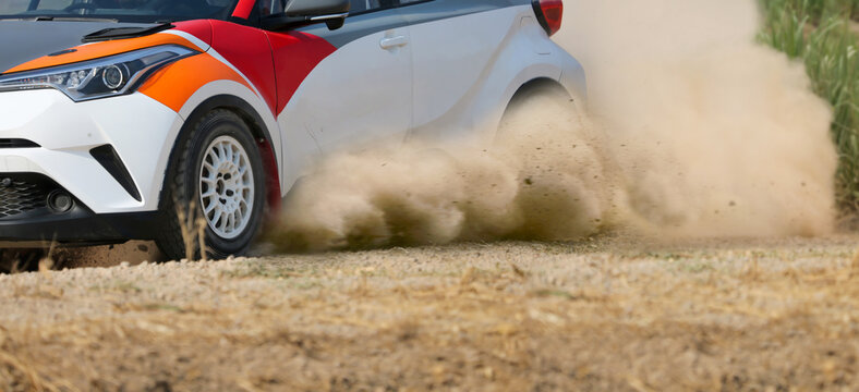 Rally race car drifting on dirt track.