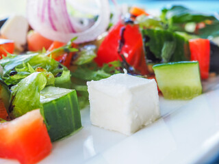 Salad with cucumber and tomato on a blue wooden background