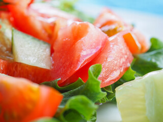Salad with cucumber and tomato on a blue wooden background