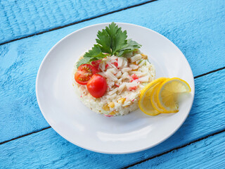 Olivier salad on a blue wooden background
