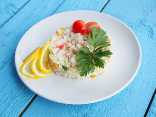 Olivier salad on a blue wooden background
