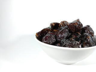Selective focus.Dried sweet dates on bowl isolated on white background. Healthy food concept.