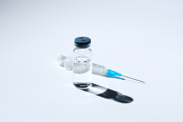 Close up glass vial with flu vaccine and syringe with needle. The concept of vaccination or...