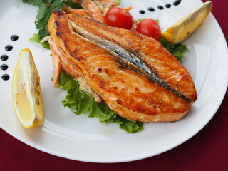 Baked salmon in foil on a red background