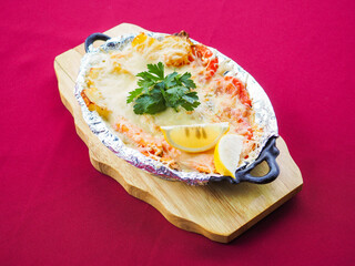 Baked salmon in foil on a red background
