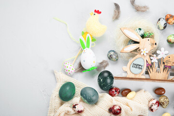 Fototapeta na wymiar Easter composition with eggs and colorful sweets on light gray background. Seasonal holiday concept.