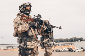 Soldier of a special forces group stands with a heavy machine gun. Special operations concept. SWAT.