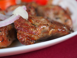Beefsteak with tomato and herbs on a red background