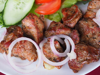 Beefsteak with tomato and herbs on a red background