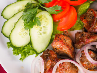 Beefsteak with tomato and herbs on a red background