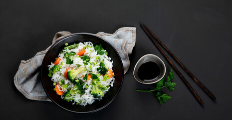 Healthy vegan rice with boiled broccoli, carrot and spring onion