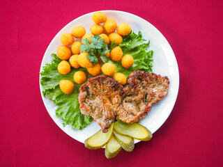 Beefsteak with tomato and herbs on a red background