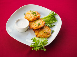Beefsteak with tomato and herbs on a red background