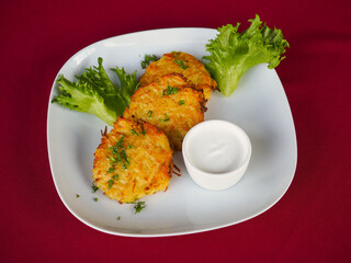 Beefsteak with tomato and herbs on a red background