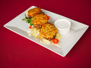 Beefsteak with tomato and herbs on a red background