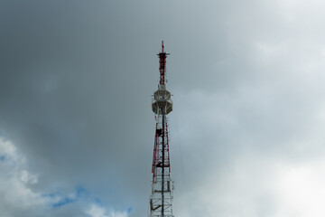 Obraz premium Telecommunication tower against the background of a gloomy gray sky, cell antenna, transmitter. TV tower