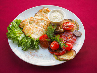 Beefsteak with tomato and herbs on a red background