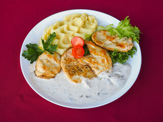 Beefsteak with tomato and herbs on a red background