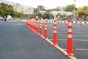 Closeup of traffic regulation pole on asphalt road with people in public park with natural background.