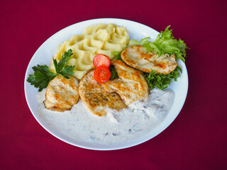 Beefsteak with tomato and herbs on a red background