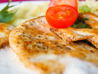 Beefsteak with tomato and herbs on a red background