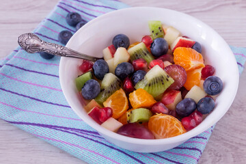 Delicious fresh fruit salad for breakfast and snack in a white bowl. 