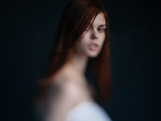 Naklejka premium Sexy women red hair bared shoulders dark background model