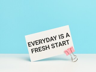 Motivational quote. Everyday is a fresh start written on white card with paper clip.
