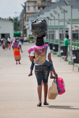 African woman with typical clothes carrying packages and big bags