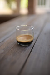 espresso shot in small curve glass on wood table vintage style