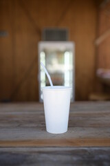 two white paper cups in cafe coffee table with mobile phone