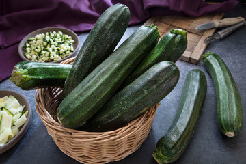Close-up of courgettes in a wicker basket on a kitchen table